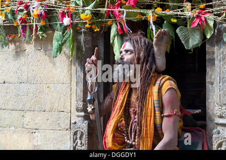 Sadhu, heiliger Mann, praktizieren Yoga gegenüber dem brennenden Ghats, Kathmandu, Kathmandu District, Bagmati Zone, Nepal Stockfoto