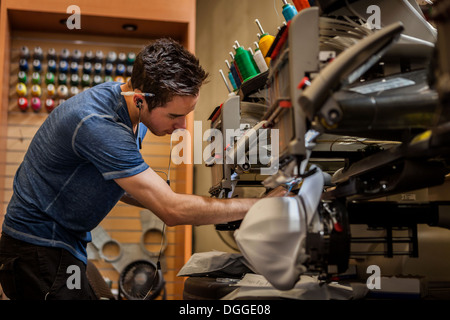Arbeiter, die Vorbereitung Stickmaschine in T-shirt Druck Werkstatt Stockfoto