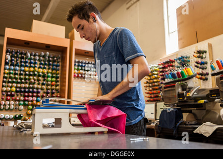 Arbeiter mit Stickmaschine in T-shirt Druck Werkstatt Stockfoto