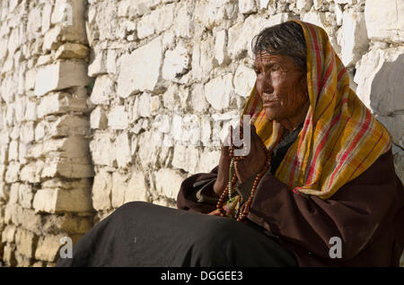 Alte Frau vor einer Mauer, Muktinath, beten senken Mustang, Nepal Stockfoto