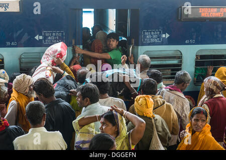 Massen von Menschen drängen in einen Zug auf einer Plattform des Bahnhofs, Allahabad, Uttar Pradesh, Indien Stockfoto