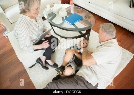 Senior woman kitzeln Enkel auf Teppich Stockfoto