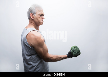 Senior woman in Sportbekleidung anhebende Brokkoli Stockfoto