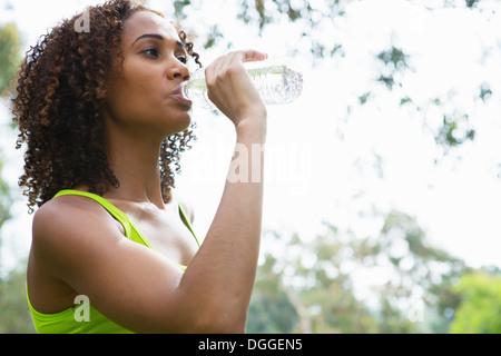 Mitte Erwachsene Frau trinken aus der Flasche Wasser