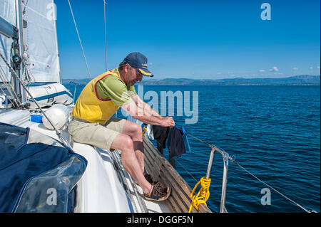 Mann, das Aufstellen von frischer Wäsche auf der Schiene von einer Segelyacht, Adria, Kroatien, Europa Stockfoto