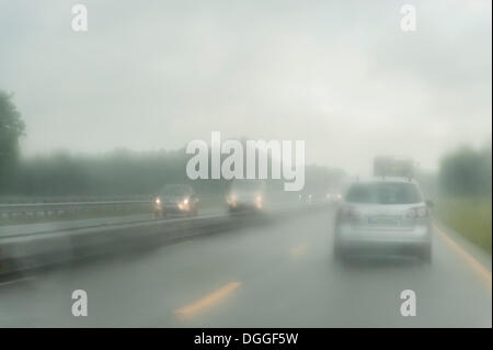 Blick durch die Windschutzscheibe eines Autos auf einer Autobahn im Regen, Niedersachsen Stockfoto