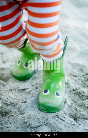 Beine des jungen männlichen Kleinkind Smiley Gummistiefel tragen Stockfoto