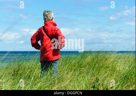 Eine Frau in den Dünen stehen und Blick auf das Meer, Insel Poel, Mecklenburg-Vorpommern Stockfoto