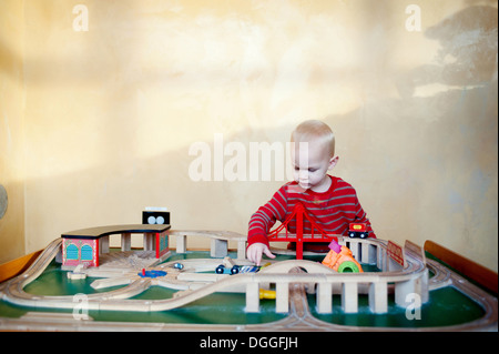 Kleiner Junge spielt mit Spielzeug-Eisenbahn-set Stockfoto