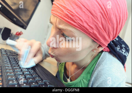 Putzfrau Reinigung einer Computertastatur, Deutschland Stockfoto