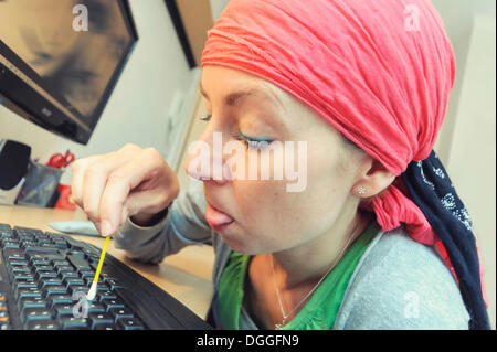 Putzfrau Reinigung eine Computer-Tastatur mit einem Wattestäbchen, Deutschland Stockfoto
