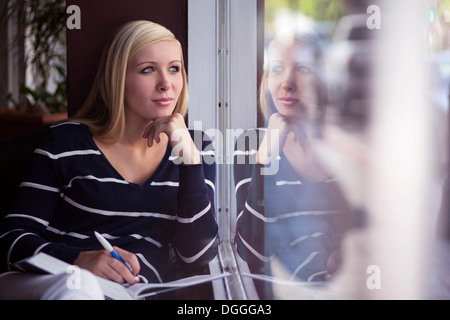 Teenager-Mädchen abgelenkt, während des Studiums im café Stockfoto