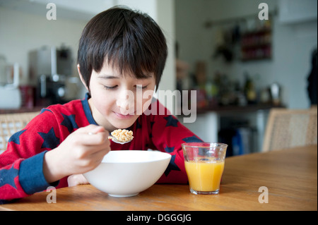 Junge, Frühstücks-Cerealien am Tisch essen Stockfoto