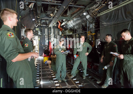 Kapitän Taylor Rigollet, Center, verleiht eine Flugberatung Besatzungsmitglieder auf eine c-130 Hercules bei Yokota Air Base, Japan, in Bereitschaft Woche 8. Oktober 2013. Bereitschaft Woche konzentriert sich auf Yokotas professionelle Luftbrücke Mission und Entwicklung Flieger abilit Stockfoto