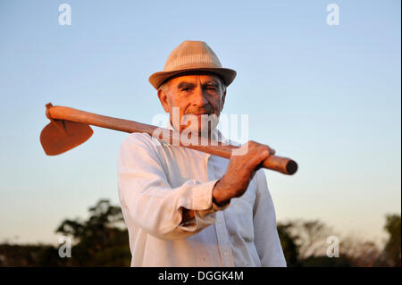 Bauer, 70, hält eine Hacke, Pastoreo, Caaguazu Abteilung, Paraguay Stockfoto