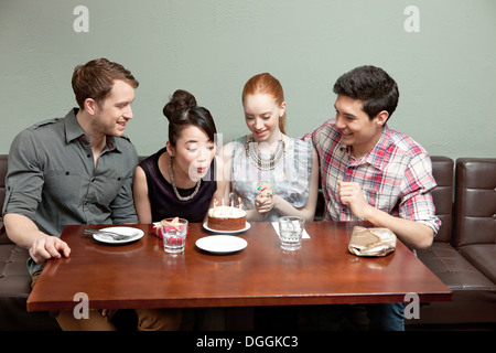 Vier Freunde feiern Geburtstag im restaurant Stockfoto