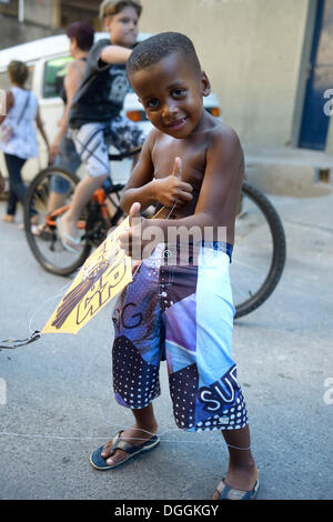 Kleiner Junge hält einen Drachen in einem Slum oder Favela, Jacarezinho Favela, Rio De Janeiro, Bundesstaat Rio De Janeiro, Brasilien Stockfoto