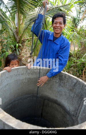 Mann holen Wasser aus einem Brunnen, Trapang Dorf, versaut Bezirk, originellen Provinz, Kambodscha Stockfoto