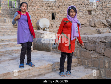 Mädchen tragen A Gasflasche In der alten kurdischen Dorf Palangan, Iran Stockfoto