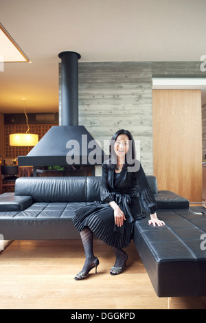 Reife Frau sitzt auf dem Sofa, Porträt Stockfoto