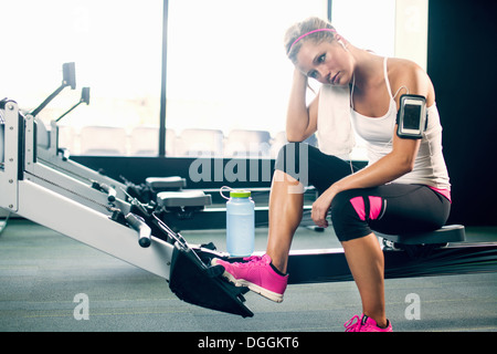 Junge Frau, die eine Pause vom Sport im Fitness-Studio Stockfoto