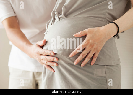 Mann rührende schwangeren Bauch, beschnitten, Porträt Stockfoto