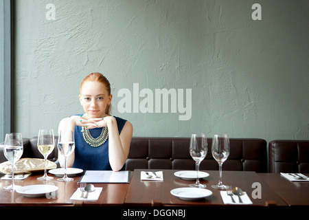 Junge Frau im Restaurant, Hand am Kinn Stockfoto