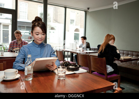Junge Frau mit digital-Tablette im café Stockfoto