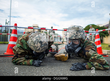 374th Medical Group Personal Low-Kraul mit einem simulierten Opfer geschnallt einen Wurf während Fähigkeit zu überleben und zu betreiben (ATSO) training 9. Oktober 2013 auf der Yokota Air Base, Japan. ATSO Schulungen abgehalten, der Flieger mit Grundkenntnissen in Kontingenz wieder vertraut. Stockfoto