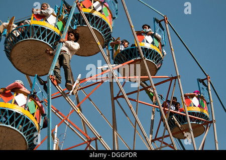 Junge indische Riesenrad-Betreiber hängen außerhalb des Rades. In Jaisalmer Wüste Festival getroffen. Stockfoto