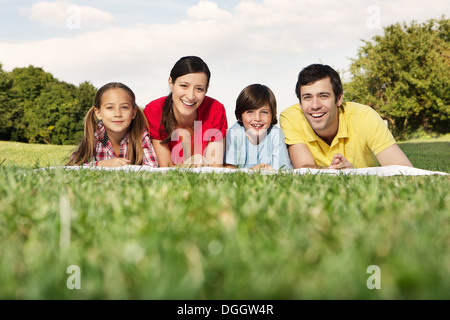 Porträt der Familie mit zwei Kindern auf dem Rasen liegend Stockfoto