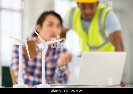 Zwei Männer mit Modellen von Windenergieanlagen im Vordergrund Stockfoto