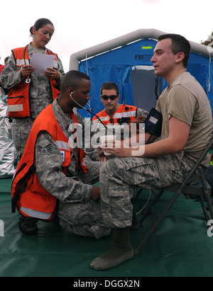 Mediziner aus der 374th Medical Group prüfen Eingeweide auf Flieger First Class Carlos Tovar, 374th Bauingenieur-Geschwader, während einer Katastrophenschutz-Übung 10. Oktober 2013, auf der Yokota Air Base, Japan. Flieger aus der 374th Airlift Wing getestet ihre capabilit Stockfoto