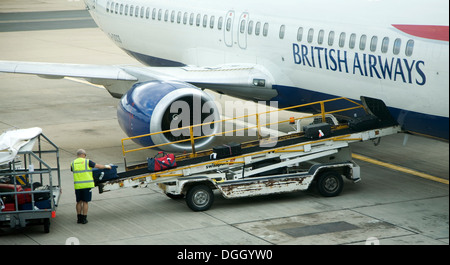 Gepäck-Handler laden Taschen auf British Airways Flugzeug Flughafen Gatwick London England Stockfoto