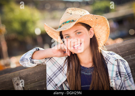 Preteen Mädchen tragen Cowboyhut Porträt im Kürbisbeet in rustikaler Umgebung. Stockfoto