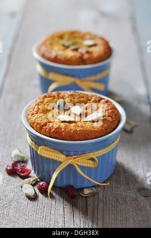 Kürbis-Muffins in Keramik Backform mit gelben Band über hölzerne Hintergrund Stockfoto