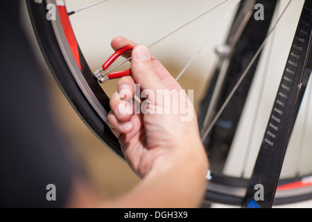 Nahaufnahme einer Person mit Nippeldreher auf Fahrrad-Rad Stockfoto
