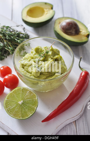 Guacamole Sauce in eine Glasschüssel über hölzerne Hintergrund Stockfoto