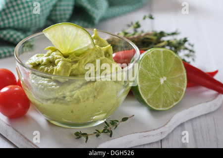 Guacamole Sauce in eine Glasschüssel über hölzerne Hintergrund Stockfoto