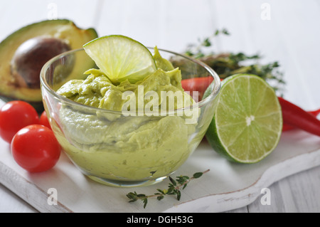 Guacamole Sauce in eine Glasschüssel über hölzerne Hintergrund Stockfoto