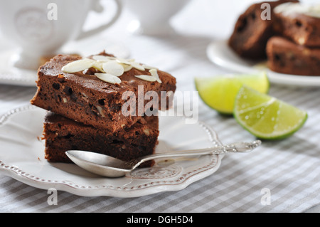 Brownie-Kuchen mit Mandelblättchen und Tasse Tee closeup Stockfoto