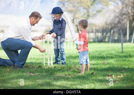 Vater und Söhne Cricket Stümpfe vorbereiten Stockfoto