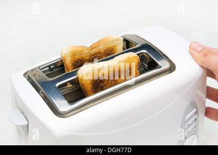 Toaster mit Brotscheiben auf weißem Hintergrund Stockfoto