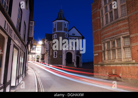 Jurassic Coast. Die malerische historische Lyme Regis Guildhall. Autoscheinwerfer sind entlang der engen und verwinkelten Bridge Street Schlieren. Dorset, England, Vereinigtes Königreich. Stockfoto