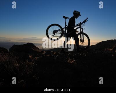 Modjeska Peak, Kalifornien, USA. 20. Oktober 2013. Mountainbiker BRIAN EPHRAIM klettert Modjeska Peak für Sunrise nach einer 5.000 ft hellen Mondnacht in Southern California Santa Ana Mountains. Mountainbiken ist der Sport der auf Fahrrädern abseits der Straße, oft über unebenes Gelände, mit speziell entwickelten Mountainbikes. Mountain-Bikes teilen Ähnlichkeiten mit anderen Bikes, sondern enthalten Funktionen, die Haltbarkeit und Leistung im Gelände zu verbessern. Diese einzelnen Sportart erfordert Ausdauer, Stärke und Balance, Fahrrad Umgang mit Fähigkeiten und Selbstvertrauen. Fortgeschrittene Radfahrer pur Stockfoto