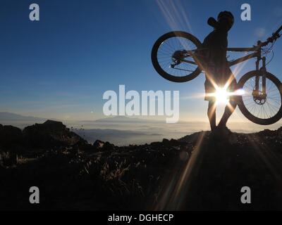 Modjeska Peak, Kalifornien, USA. 20. Oktober 2013. Mountainbiker BRIAN EPHRAIM klettert Modjeska Peak für Sunrise nach einer 5.000 ft hellen Mondnacht in Southern California Santa Ana Mountains. Mountainbiken ist der Sport der auf Fahrrädern abseits der Straße, oft über unebenes Gelände, mit speziell entwickelten Mountainbikes. Mountain-Bikes teilen Ähnlichkeiten mit anderen Bikes, sondern enthalten Funktionen, die Haltbarkeit und Leistung im Gelände zu verbessern. Diese einzelnen Sportart erfordert Ausdauer, Stärke und Balance, Fahrrad Umgang mit Fähigkeiten und Selbstvertrauen. Fortgeschrittene Radfahrer pur Stockfoto