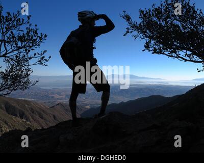 Modjeska Peak, Kalifornien, USA. 20. Oktober 2013. Mountainbiker BRIAN EPHRAIM nimmt den Panoramablick vom Modjeska Peak nach 5.000 ft Mond Licht Nacht Fahrrad fahren in Southern California Santa Ana Bergen. Mountainbiken ist der Sport der auf Fahrrädern abseits der Straße, oft über unebenes Gelände, mit speziell entwickelten Mountainbikes. Mountain-Bikes teilen Ähnlichkeiten mit anderen Bikes, sondern enthalten Funktionen, die Haltbarkeit und Leistung im Gelände zu verbessern. Diese einzelnen Sportart erfordert Ausdauer, Stärke und Balance, Fahrrad Umgang mit Fähigkeiten und Selbstvertrauen. ADVA Stockfoto