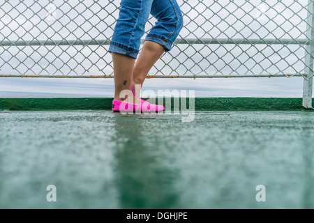 Kanadische Teenager unterhalb der Taille abwärts mit aufgerollt Jeans und helle Rosa Slipper am Geländer der Fähre, PEI, Kanada Stockfoto