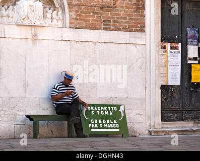 Gondoliere sitzen auf einer Bank unterzeichnen Gondolieri, warten auf Kunden, für die Gondeln in Venedig, Veneto, Italien, Europa Stockfoto