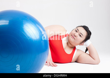 ein dickes Mädchen in einem Fitness-Studio-Outfit auf dem Boden liegend Stockfoto